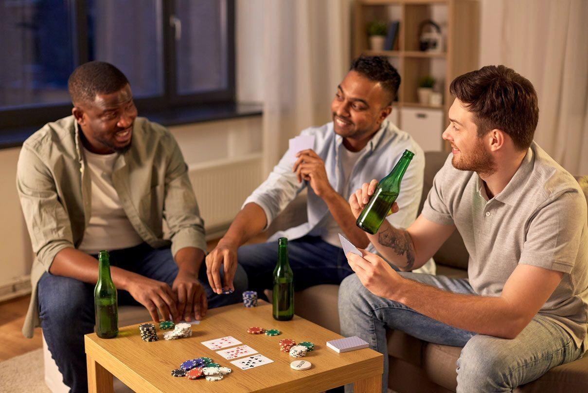 Three friends playing poker at a home game with chips and cards