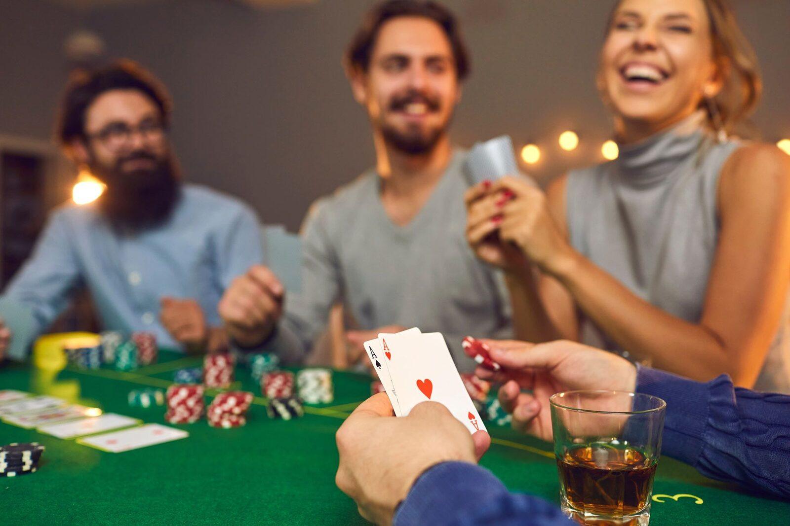 Friends laughing around a green felt table during a home poker tournament