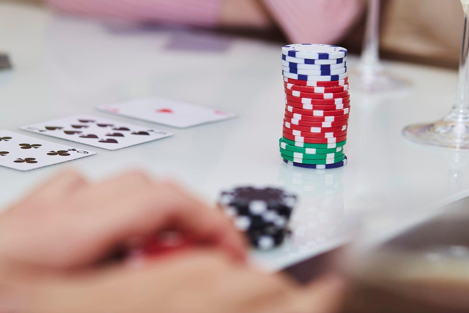Poker chips stacked beside community cards on a bright table
