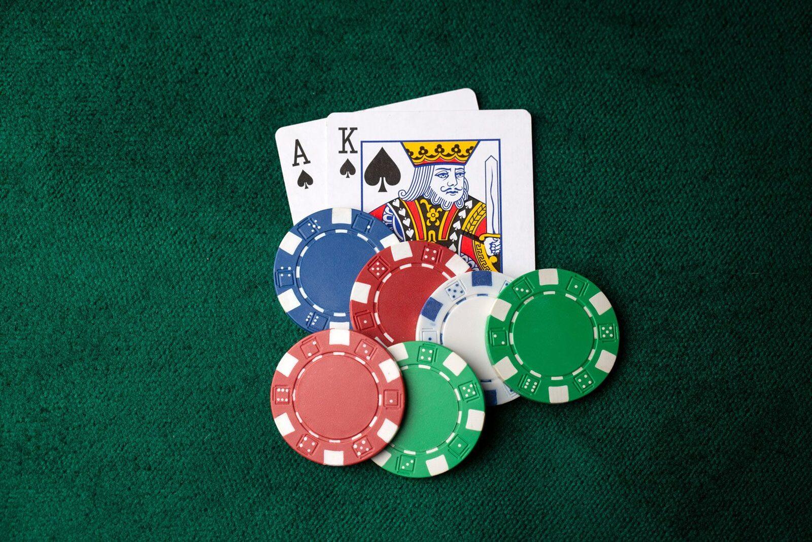 An ace and a king beside stacks of coloured poker chips