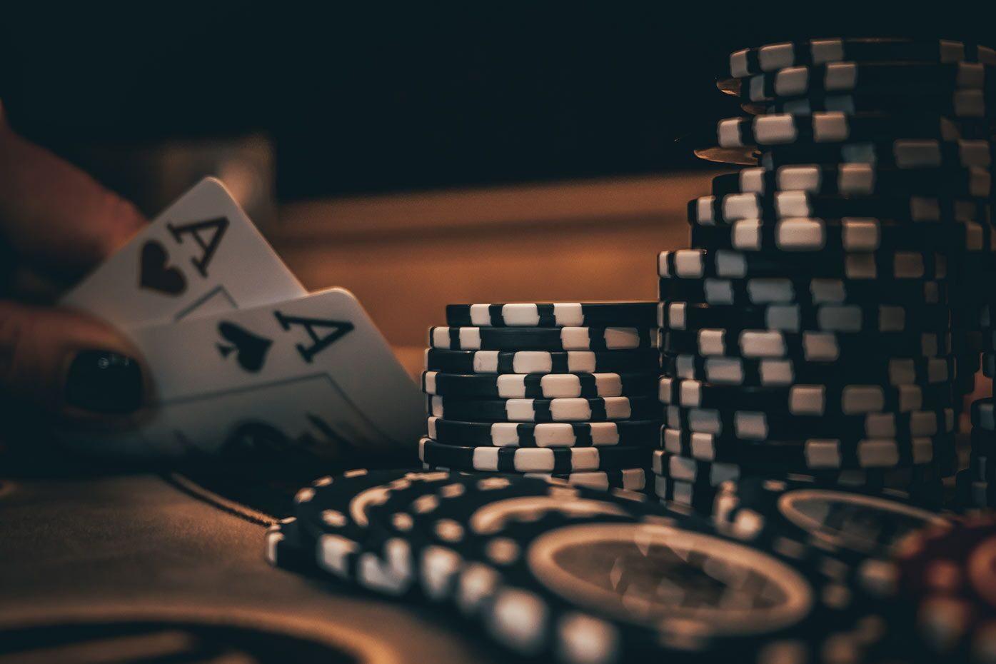 A pair of aces beside tall stacks of black and white poker chips